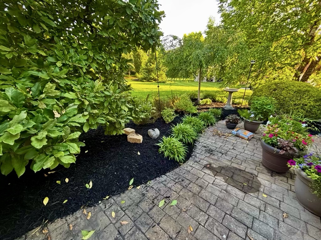 Fresh mulch beside a garden patio and plantings